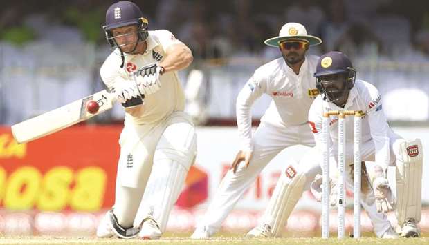 Englandu2019s Jos Buttler (left) plays a shot on the third day of the third Test against Sri Lanka in Colombo yesterday. (AFP)