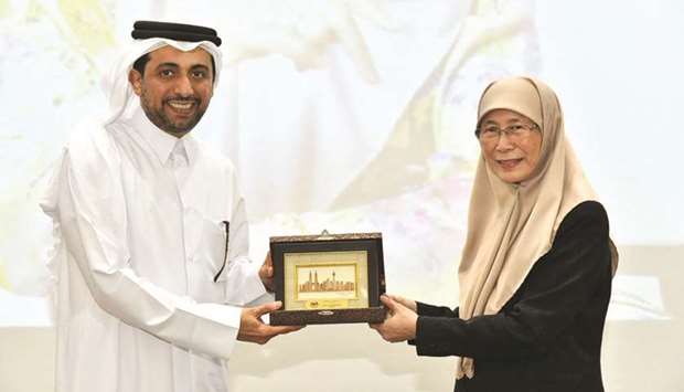 Malaysiau2019s Deputy Prime Minister and Minister of Women, Family and Community Development Wan Azizah Wan Ismail presenting a memento to QU president Dr Hassan al-Derham yesterday.