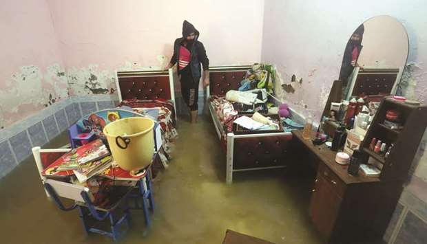 A man inspects his home after heavy rainfall in the town of Qalu2019at Sukkar, north of Nassiriya, Iraq yesterday.