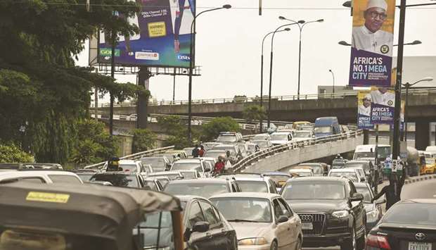 Motorists wait in a traffic jam under banners bearing a portrait of President Muhammadu Buhari in Lagos.