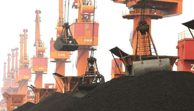 Imported coal is unloaded by cranes from a coal cargo ship at a port in Lianyungang, Jiangsu province. Chinau2019s coal imports are set to slump in December as traders and utilities wind back purchases following signals from Beijing that it will stop clearing shipments until next year, trading companies and utilities told Reuters.