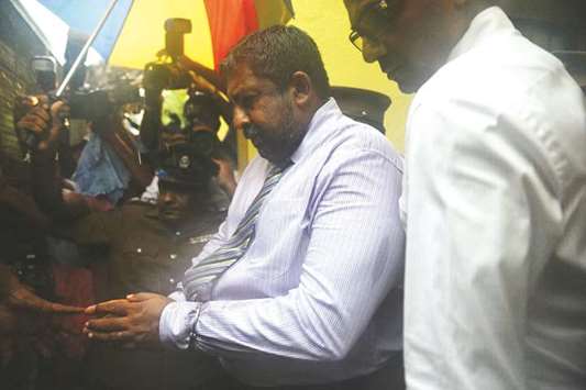 Admiral Ravindra Wijegunaratne is being escorted to a prison in Colombo yesterday.