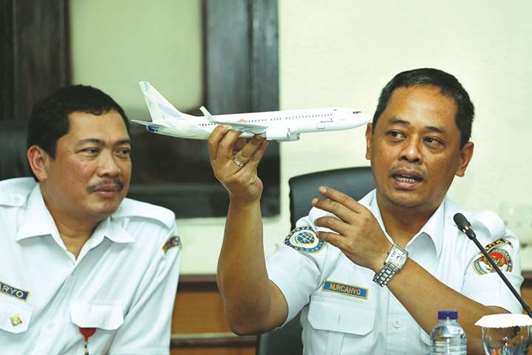 National Transportation Safety Committee sub-committee head for air accidents, Nurcahyo Utomo, holds a model airplane while speaking next to deputy chief of KNKT Haryo Satmiko during a news conference on its investigation into a Lion Air plane crash last month, in Jakarta.