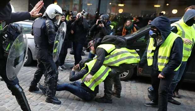 Protesters wearing yellow vests, a symbol of a drivers' protest against higher fuel prices, stand in front of police during a demonstration in central Brussels, Belgium