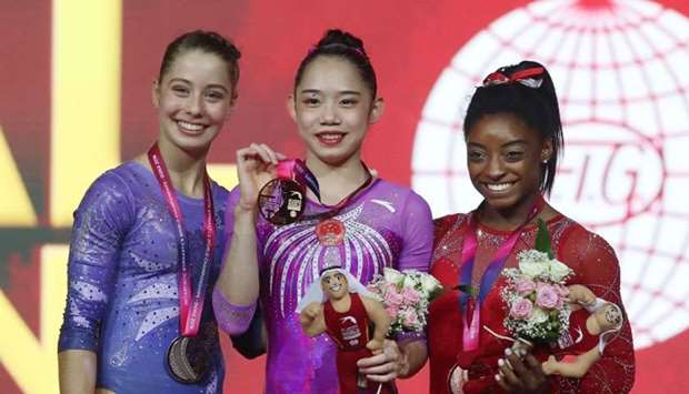 (From L) Canada's Anne-Marie Padurariu (silver), China's Liu Tingting (gold) and US Simone Biles (bronze) pose with their medals on the podium