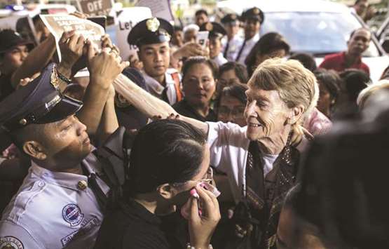 Australian nun Patricia Fox is surrounded by supporters as she arrives at the departure area of the Manila International Airport, yesterday.