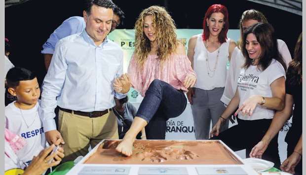 Colombian singer Shakira places her foot on a cement cornerstone in Barranquilla during the groundbreaking ceremony for the construction a school supported by her foundation Pies Descalzos and the Barca Foundation.
