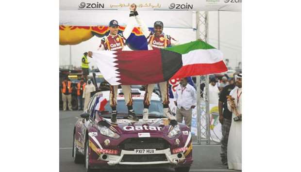 Qataru2019s Nasser Saleh al-Attiyah (right) and his co-driver Mathieu Baumel celebrate their victory in the Kuwait International Rally yesterday. This was al-Attiyahu2019s seventh win in Kuwait.