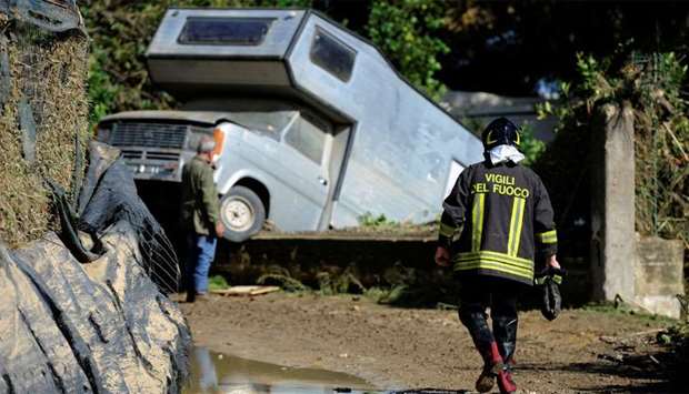 A fireman walks on a mud covered path in the aftermath of a flood in Casteldaccia, near Palermo