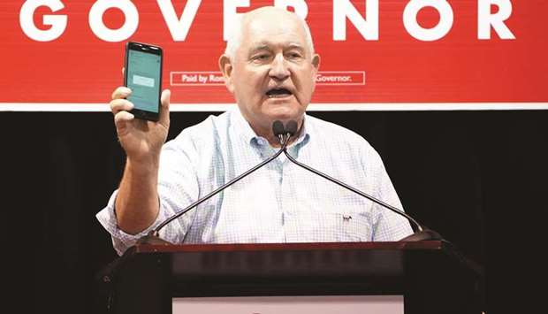 United States Secretary of Agriculture Sonny Perdue holds up a phone as he attends a rally for candidate for governor Ron DeSantis in Lakeland, Florida.