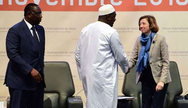 Gambia's President Adam Barrow (C) shakes hands with French Defence Minister Florence Parly (R) as they stand next to Senegal's President Macky Sall (L)