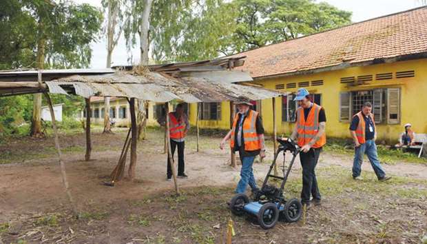 David MacMillan, an expert from SparrowHawk Far East company, operating the ground-penetrating radar machine during a search for mass graves at a school compound in Prey Veng province of Cambodia.