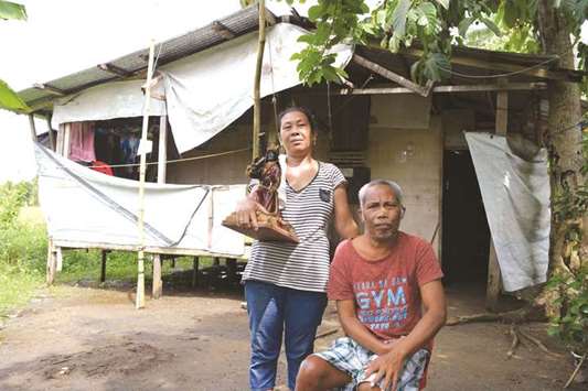 Typhoon Haiyan survivor Elsie Indic, 46, standing next to her husband in front of their house in Tolosa town, Leyte province, central Philippines.