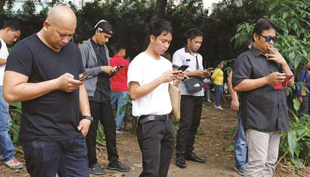 Filipinos use their mobile phones at a park in Taguig, Metro Manila. Paying some of Asiau2019s highest telecom charges while suffering slow Internet and frequent dropped calls, Filipinos will expect better service once the government picks a new entrant to break a duopoly in a market worth $5.1bn annually.