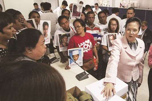 PAO chief Persida Acosta assists relatives of Dengvaxia victims during the filing of additional charges against health officials at the Department of Justice in Manila.
