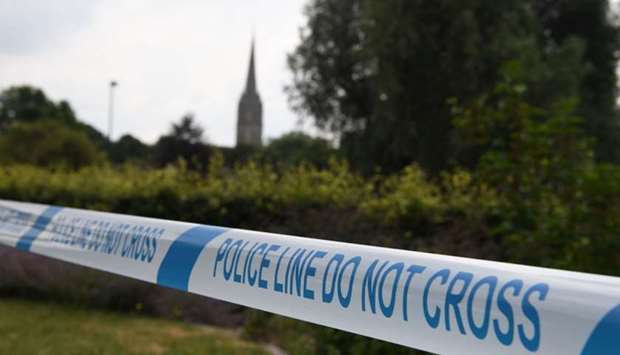 The spire of Salisbury Cathedral is seen behind police tape making a cordon around Queen Elizabeth Gardens in Salisbury, southern England, on July 5, 2018 cordoned off in connection with the investigation and major incident declared after a man and woman were found unconscious after exposure with what was later identified as the nerve agent Novichok.