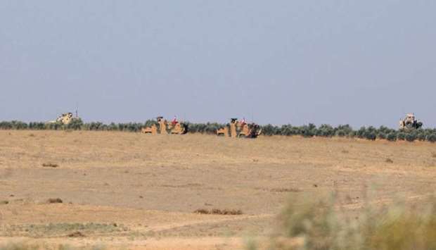 A Turkish flag flutters on a military vehicle on the border of Manbij city, Syria