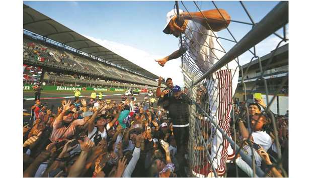 Mercedes driver Lewis Hamilton celebrates winning the 2018 driversu2019 title with his fans after the Mexican Grand Prix on October 28, 2018. (AFP)