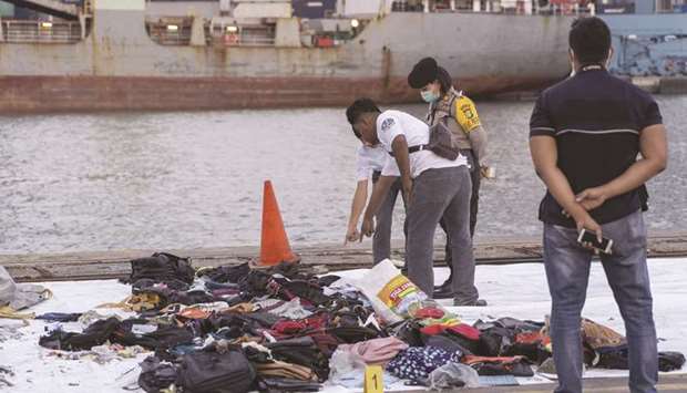 Search and rescue team members look at debris recovered from the crash site on the dockside at Tanjung Priok Port in Jakarta on October 29. The Lion Air 737 Max 8 jetliner plunged into the Java Sea minutes after takeoff from Jakarta airport, nosing downward so suddenly that it may have hit speeds of 600 miles an hour before slamming into the water.