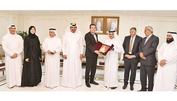Qatar Chamber chairman Shiekh Khalifa bin Jassim al-Thani handing over a token of recognition after a meeting with the Algerian trade delegation in Doha yesterday.