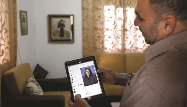 The uncle of Rashida Tlaib, the first Palestinian-American woman to be elected to the US Congress, shows her picture on a tablet, in Beit Ur Al-Fauqa, in the occupied West Bank, yesterday.