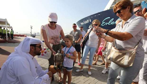 A Qatari and his falcon welcome Mein Schiff 4 passengers as they disembark from the cruise ship.