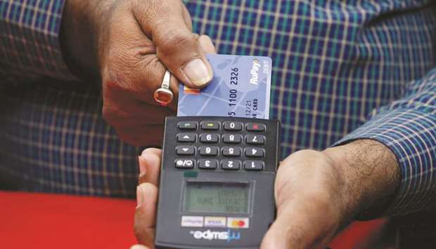 A shopkeeper swipes a customeru2019s debit card with the logo of RuPay at an electronics goods store in Kolkata, India. RuPay process payments between banks and merchants for purchases made with credit or debit cards, while Unified Payment Interface instantly transfers funds between two bank accounts linked to mobile phones.
