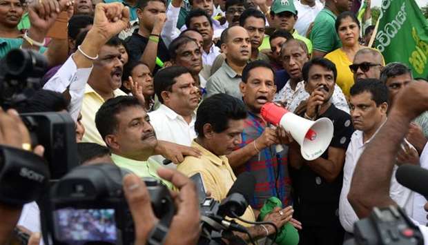 Sri Lankan politician Rajitha Senaratne (C) addresses a rally of supporters of deposed prime minister Ranil Wickremesinghe in the capital Colombo yesterday.