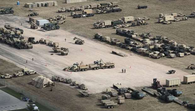 US Army vehicles sit parked at a new military camp under construction at the US-Mexico border on November 7, 2018 in Donna, Texas.