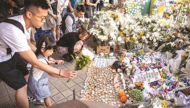 Mourners place flowers by a makeshift memorial at the car park where student Alex Chow, 22, fell during a recent protest in the Tseung Kwan O area on the Kowloon side of Hong Kong yesterday.