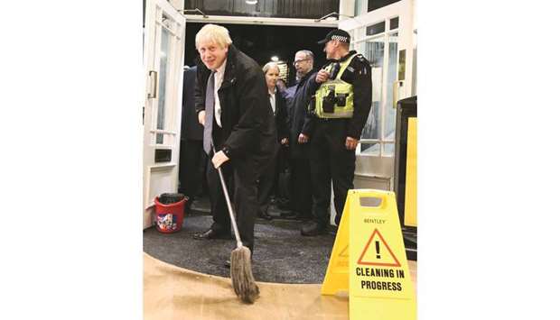 Johnson helps with the clean-up at an opticians shop in Matlock, northern England, on Friday evening after it was affected by flooding.