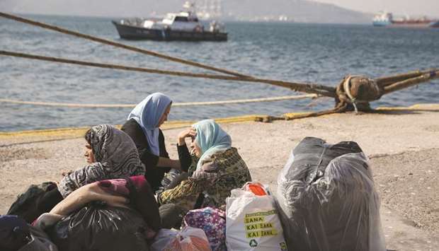 This picture taken on October 22 shows refugees and migrants waiting to be transferred to camps on the mainland, at the port of Elefsina, near Athens.