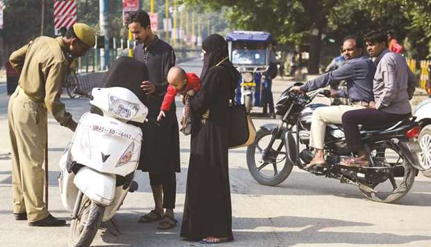 A security personnel checks a motorist at a roadblock in Ayodhya yesterday.