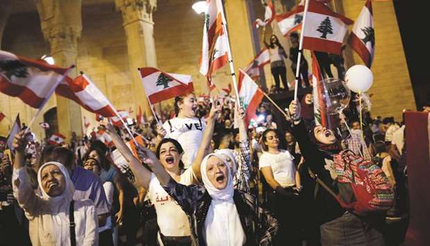 People wave Lebanese flags as they attend a demonstration at Martyrsu2019 Square during ongoing anti-government protests in Beirut, yesterday.