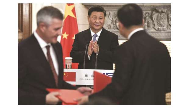 Xi Jinping, Chinau2019s president (centre), reacts as Greek and Chinese representatives sign agreements following his meeting with Greek Prime Minister Kyriakos Mitsotakis (not pictured) at Maximos mansion in Athens yesterday. The two countries will co-operate in many sectors and u201cwe want to strengthen the transit role of Piraeus Port to expand bilateral trade and to invest in energy, transportation and the banking sector,u201d Xi said.