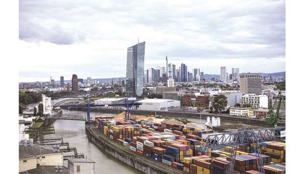 The skyscraper headquarters of the European Central Bank (centre) stands on the city skyline as shipping containers sit on the quayside at the Osthafen container dock in Frankfurt. German economy probably dipped into a technical recession in the third quarter, shrinking 0.1%, according to just over half of the 39 forecasts in a Bloomberg survey of economists.