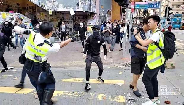 A still image from a social media video shows a police officer aiming his gun at a protester in Sai Wan Ho, Hong Kong