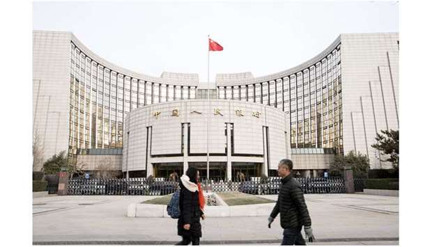 Pedestrians walk past the Peopleu2019s Bank of China headquarters in Beijing. As China prepares to become the first country to launch a digitised domestic currency, market participants and experts say it is a testament to both financial innovation and Beijingu2019s desire to have fail-safe control over its cash economy.