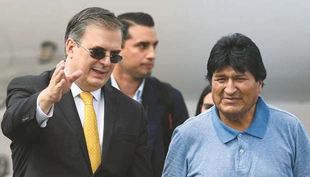 Mexican Foreign Minister Marcelo Ebrard (left) receives Bolivian ex-president Evo Morales upon his arrival in Mexico City yesterday.
