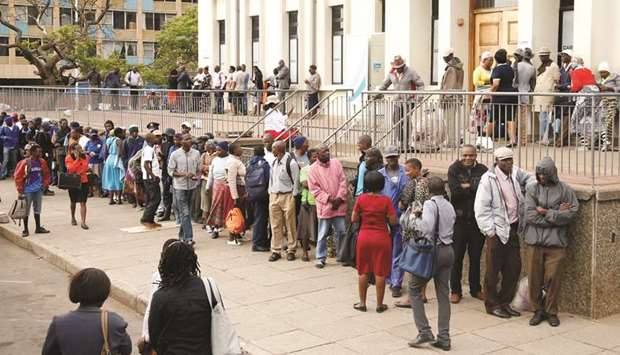 People queue to withdraw money from a bank in Harare yesterday.