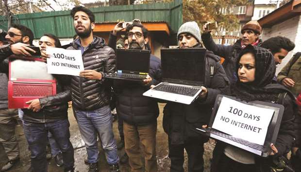Kashmiri journalists display laptops and placards during a protest demanding restoration of Internet service, in Srinagar, yesterday. Since August political activity in Kashmir has been curtailed, journalists have been refused free access, and NGOs have reported human rights abuses, claims denied by India.