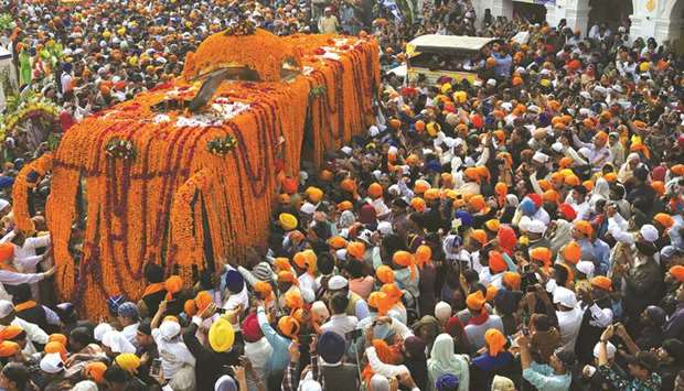 Pilgrims gather yesterday around the Palki Sahib on the 550th birth anniversary of Guru Nanak Dev, in Nankana Sahib.