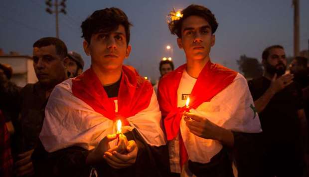 Iraqis march with lit candles during the funeral of a protester killed in anti-government demonstrations, in the southern city of Basra.