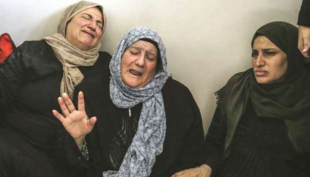 Relatives of a Palestinian groupu2019s senior leader Baha Abu al-Ata mourn during his funeral in Gaza City, yesterday.