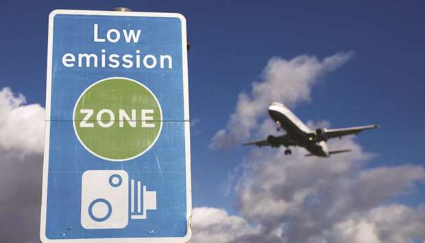 An aircraft passes a low emission zone sign as it prepares to land at Heathrow airport in London. Aviation accounted for 13% of all transport emissions, according to the European Union Aviation Safety Agency.