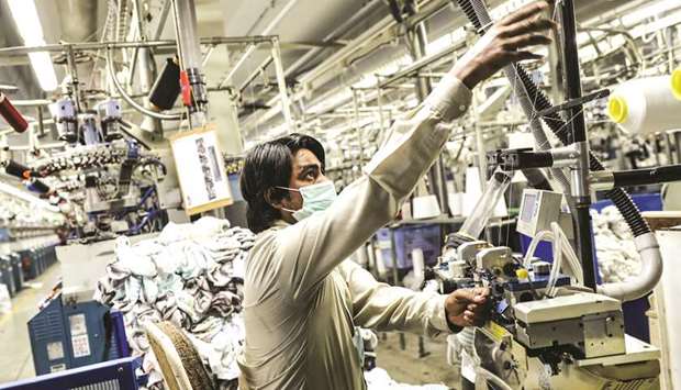 An employee operates machinery in the knitting section of a garment factory in Faisalabad, Pakistan (file).