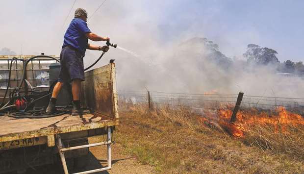 Tinonee resident Brian Acheson sets up his tip truck as a makeshift fire truck to assist residents fighting spot and grass fires in the Hillville area near Taree, NSW, Australia.