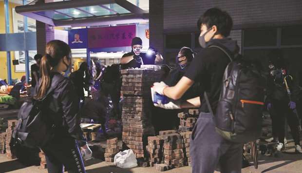 Anti-government protesters build a brick wall as a roadblock during a hold-up against the police at the Chinese University of Hong Kong.