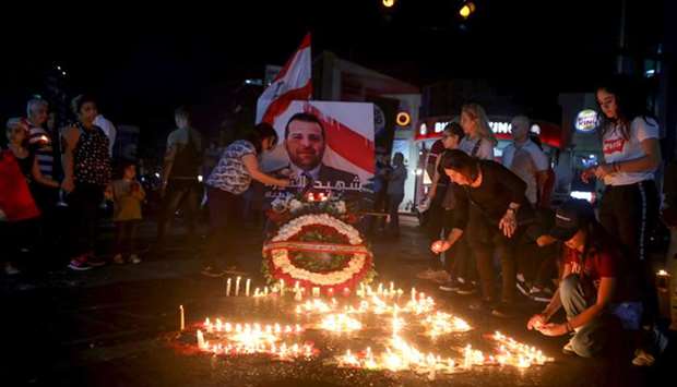 Lebanese demonstrators hold a candle light vigil in the capital Beirut yesterday, for Alaa Abu Fakher (photo), killed the day before during ongoing anti-government protests.
