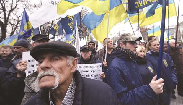 Ukrainian farmers and activists protest land sale reform in front of the parliament in Kyiv yesterday.
